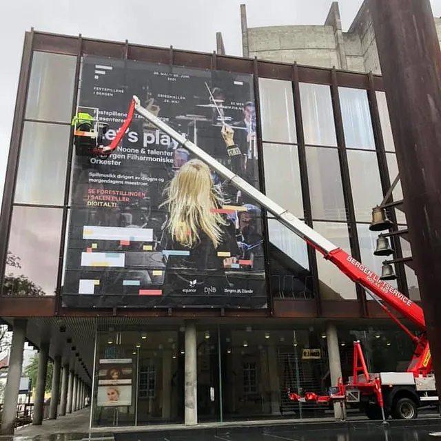 Rød lift henger opp plakat